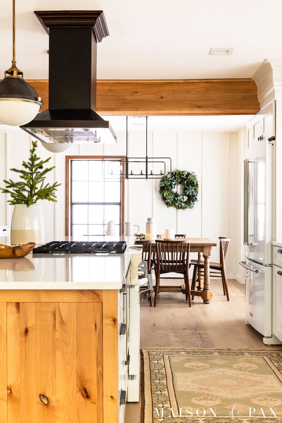 white and wood kitchen with rustic beams, farm table, and holiday greenery | Maison de Pax