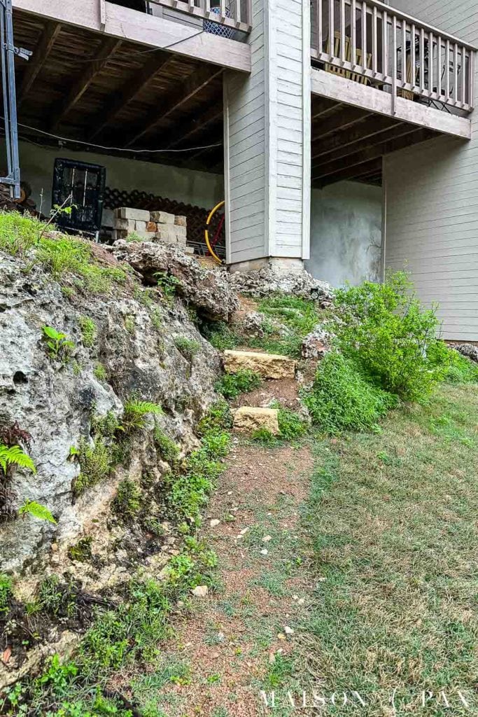 stone steps and crushed granite walkway overgrown with grass and weeds