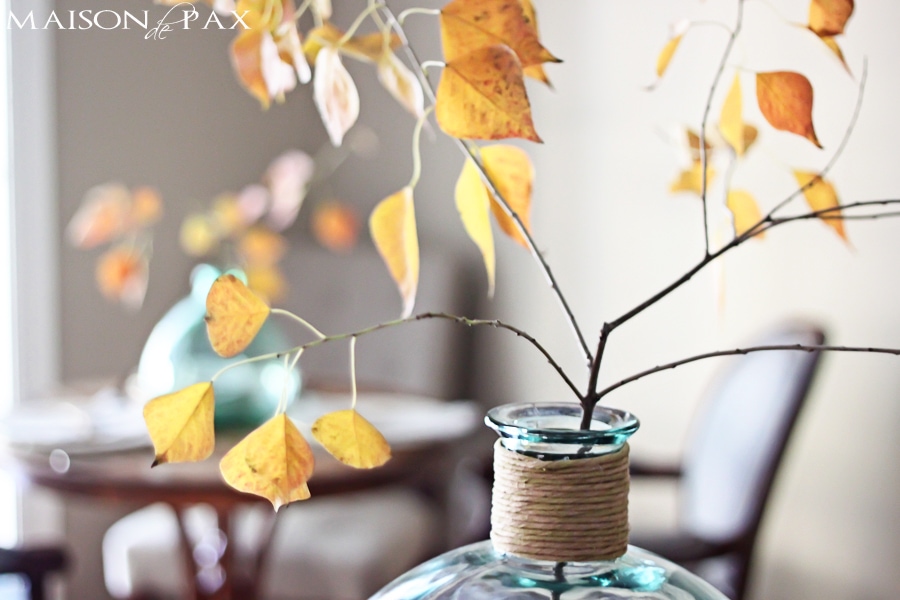 Lovely, simple Thanksgiving tablescape: a grand table and a side table with fall foliage centerpieces, simple neutral china settings, and a few pumpkins | aiweb9ygdry.cmersite.com