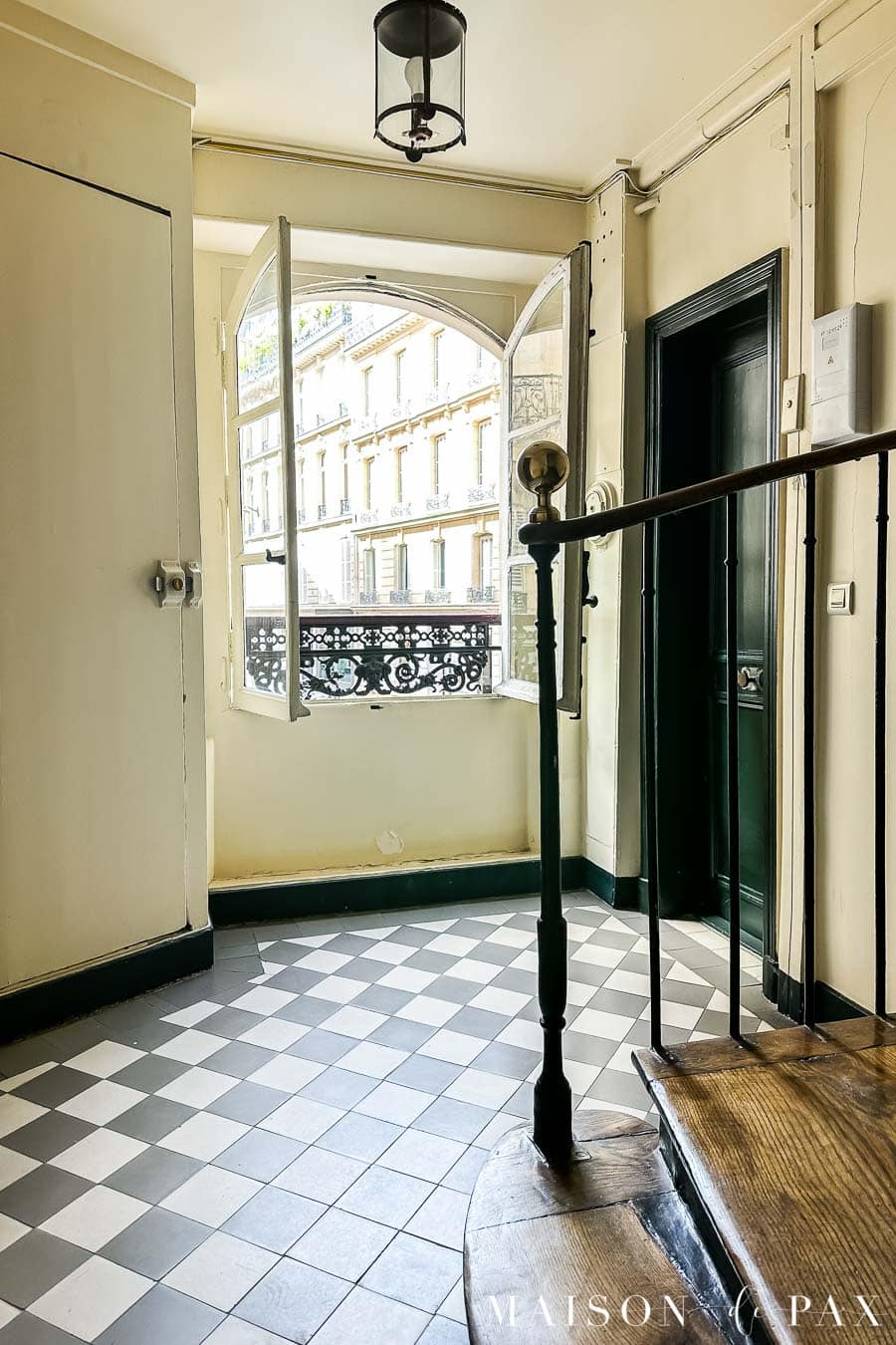 black and white checkerboard flooring in parisian apartment stairwell landing