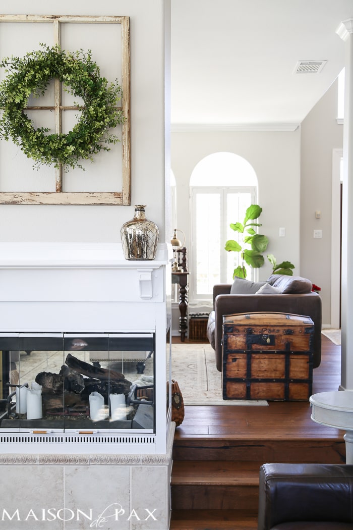 Love the wreath over the antique window above the mantel... What a beautiful home with light touches of greenery perfect for spring or summer | aiweb9ygdry.cmersite.com