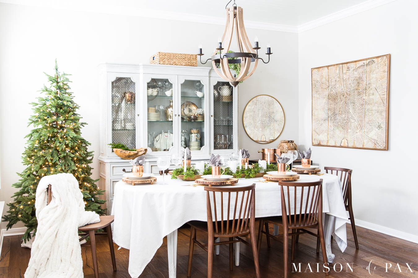 modern farmhouse dining room with walnut chairs and a simple green tree