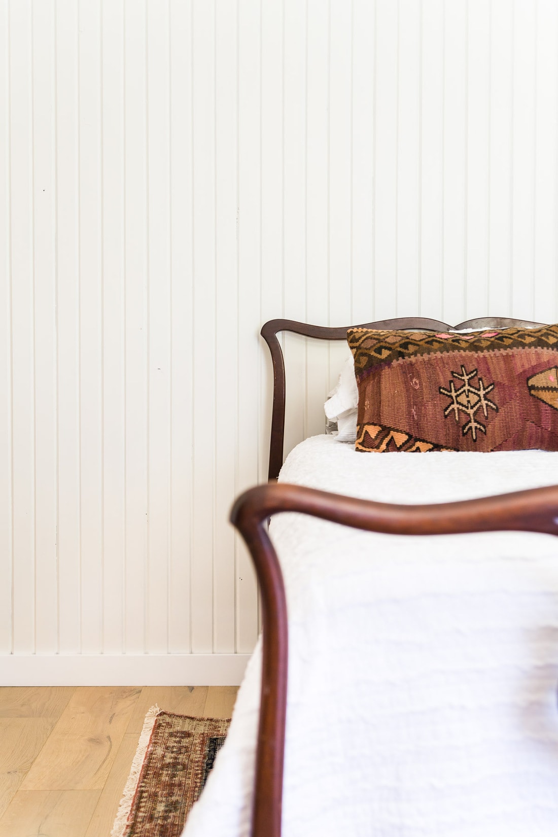 white painted vertical skinny shiplap walls with antique bed | Maison de Pax