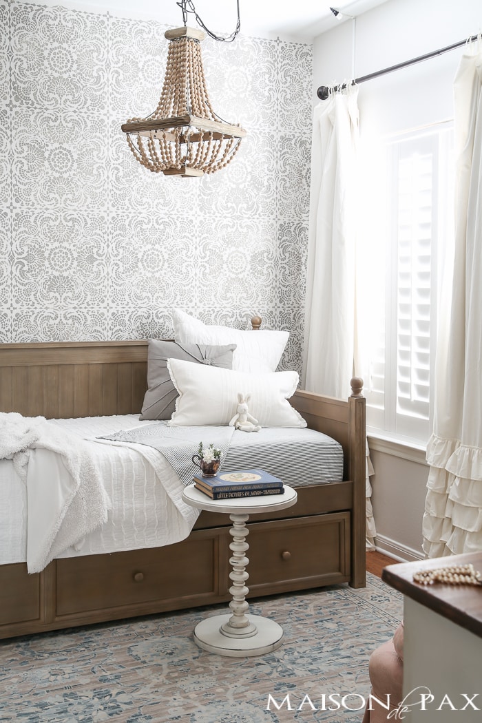 Elegant, neutral little girl room with wood tones and a stenciled accent wall: A gray-washed trundle bed provides the perfect anchor for a gorgeous, neutral yet feminine little girl's room.