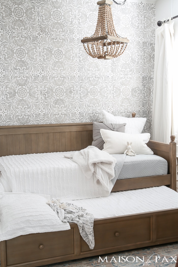 Elegant, neutral little girl room with wood tones and a stenciled accent wall: A gray-washed trundle bed provides the perfect anchor for a gorgeous, neutral yet feminine little girl's room.