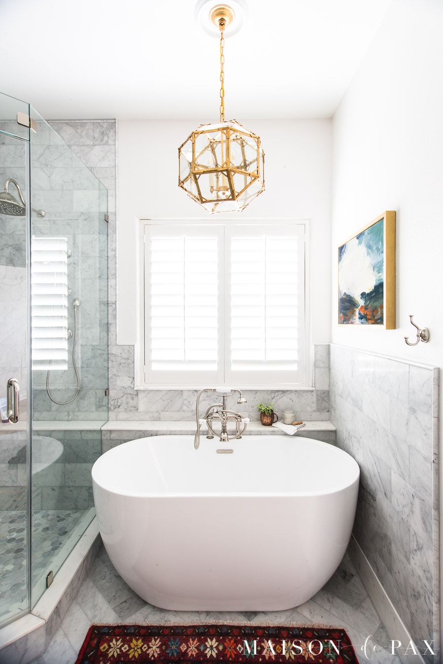 freestanding tub in marble bathroom with vintage rug and abstract art | Maison de Pax