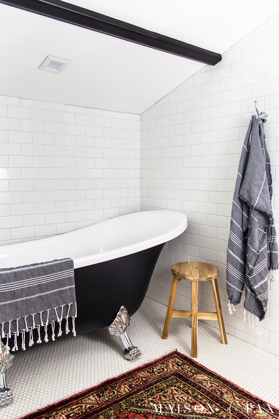 low angled ceiling above clawfoot tub in classic black and white bathroom | Maison de Pax