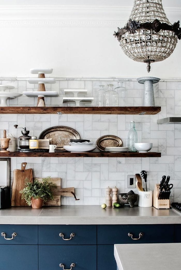 navy lower cabinets, open rustic wood floating shelves, marble backsplash
