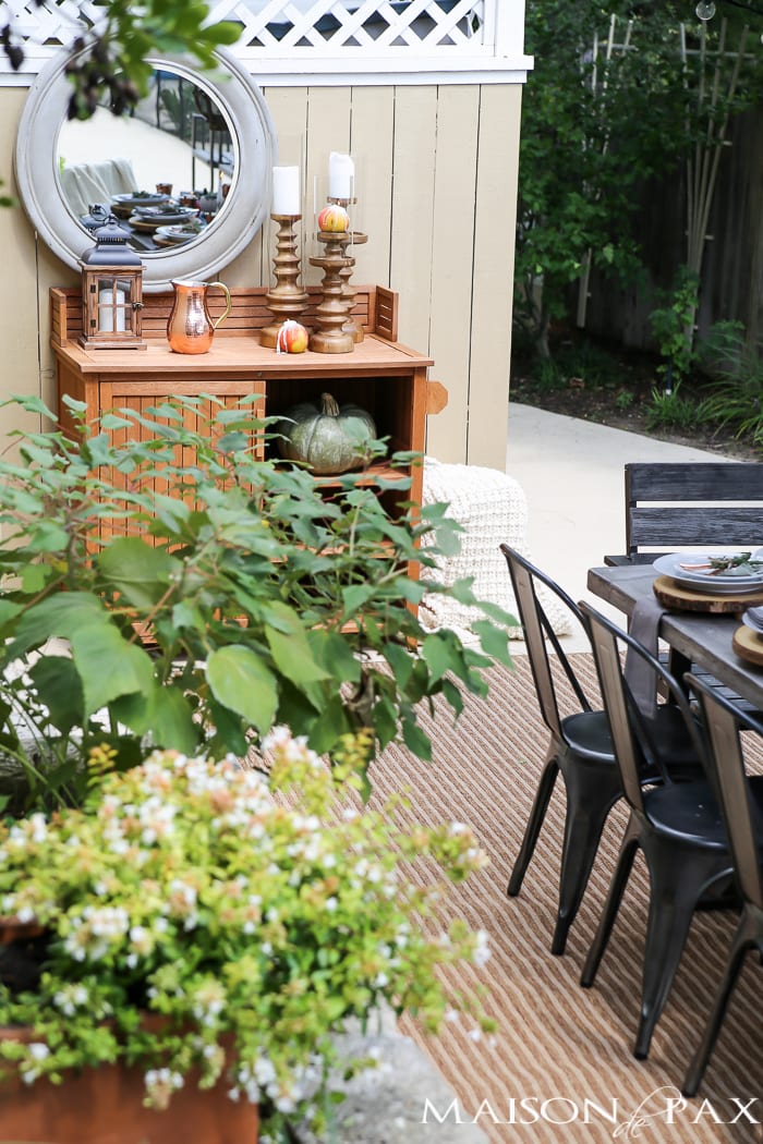 outdoor fall tablescape: lanterns, string lights, apple candles, and other cozy outdoor fall decorating ideas!