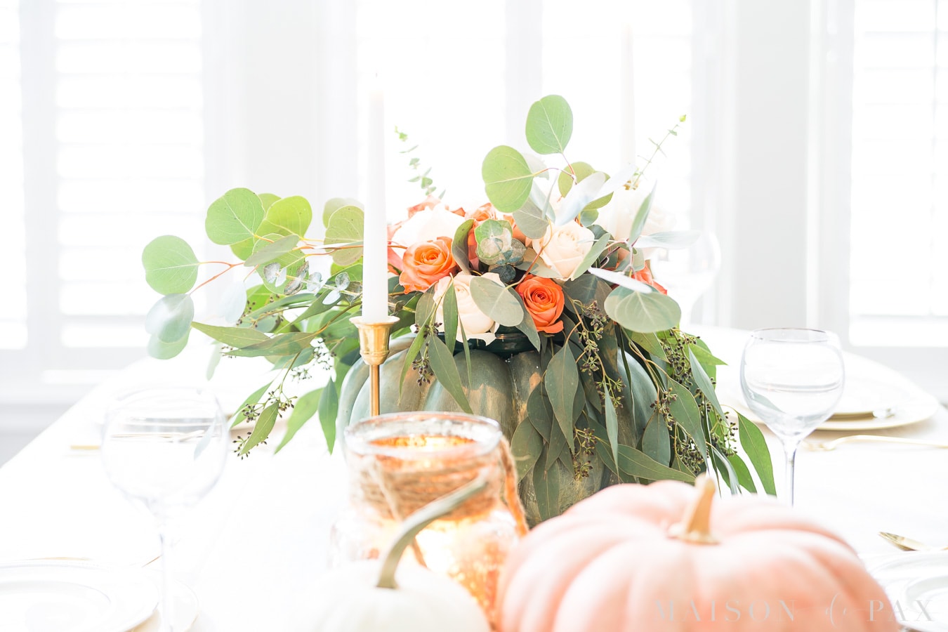 pumpkin floral centerpiece with brass candlesticks and pink and white and green pumpkins