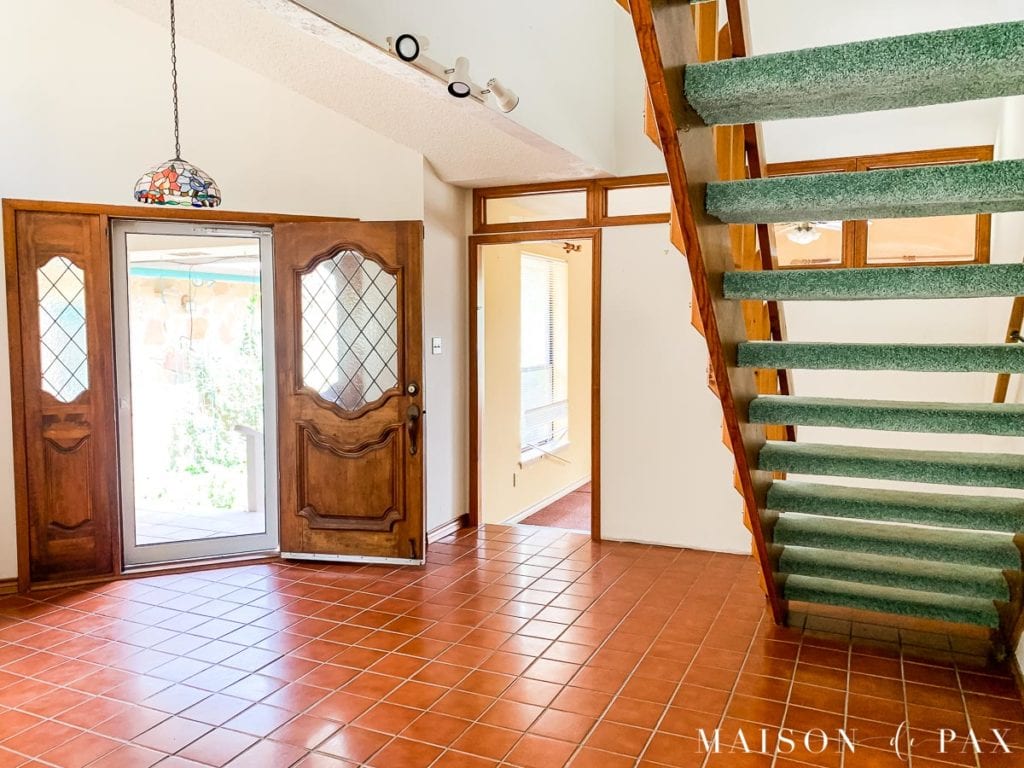 entryway with orange wood stairs