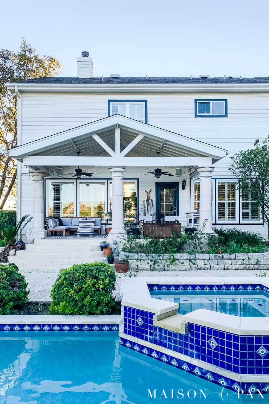 back of house with white siding and black trim around white windows | Maison de Pax