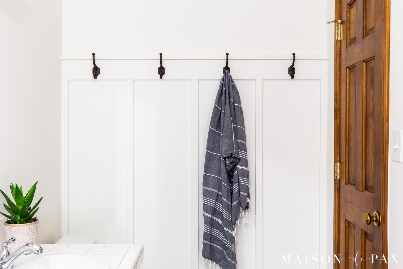 board and batten accent wall with towel hooks | Maison de Pax