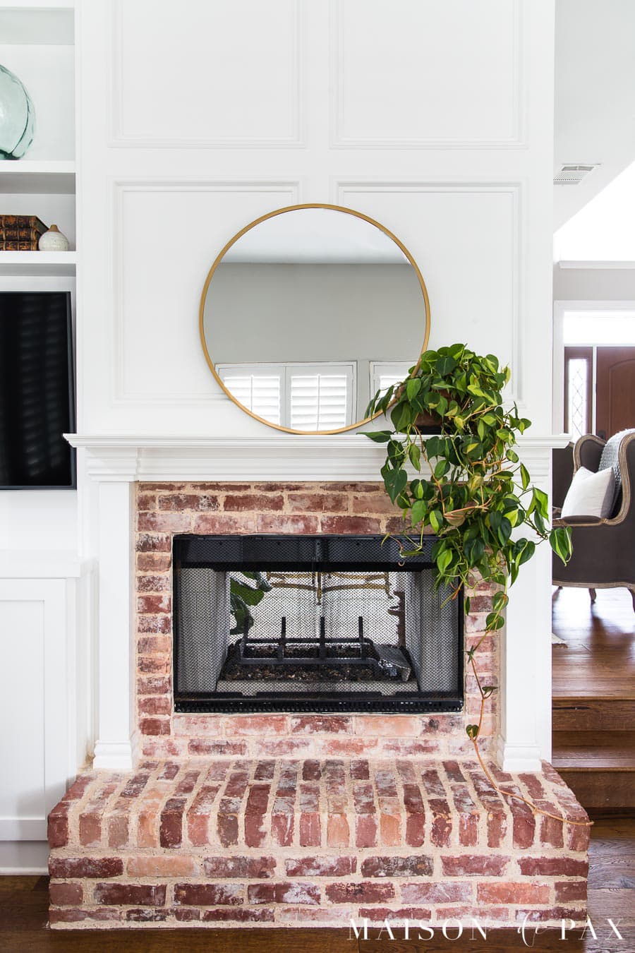 round brass mirror above mantel with trailing philodendron | Maison de Pax