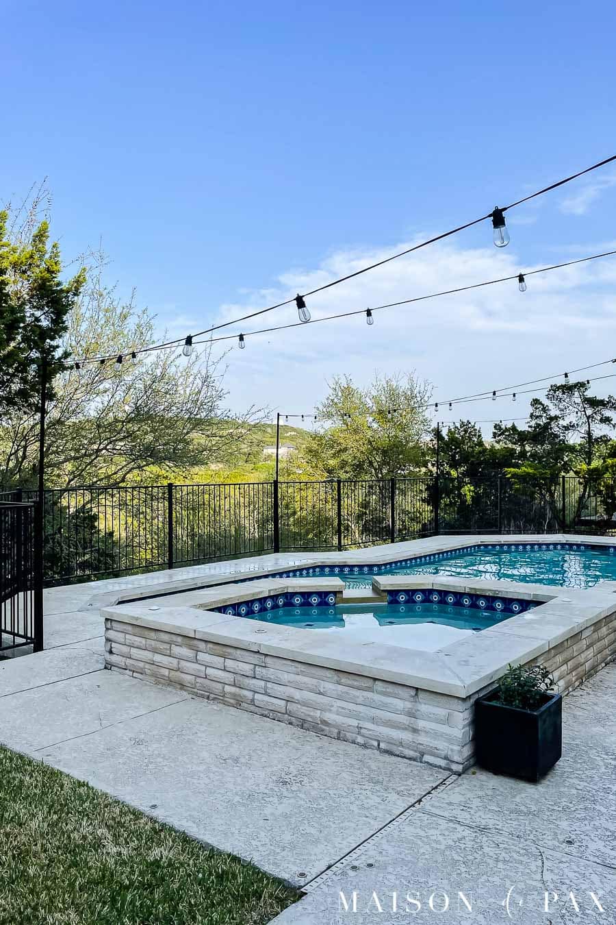 aluminum poles used to hang outdoor string lights on a black iron fence