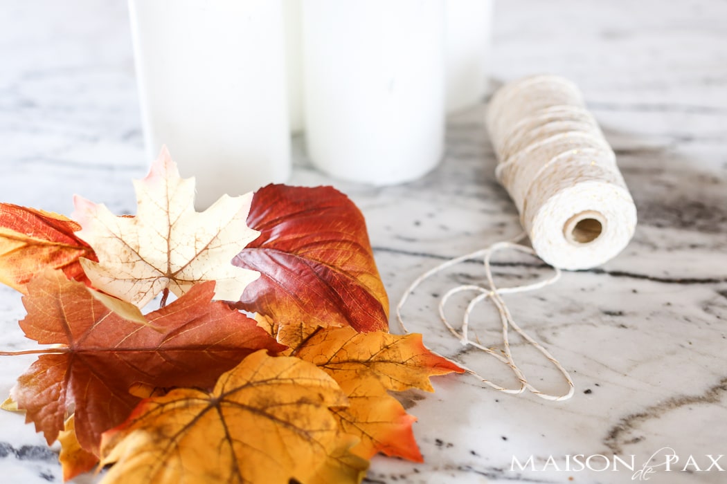 fall craft idea: white pillar candles, fall leaves, baker's twine