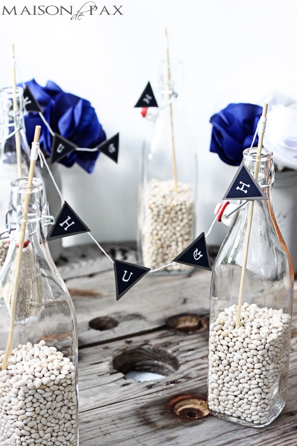 navy and gray bunting with white letters in bottles with dried beans | Maison de Pax