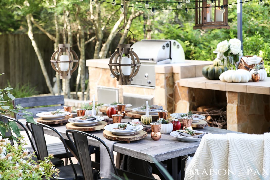 outdoor fall tablescape: lanterns, string lights, apple candles, and other cozy outdoor fall decorating ideas!