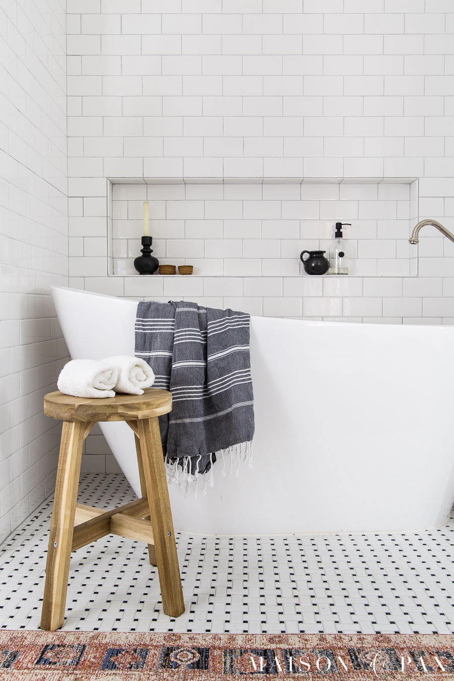 freestanding slipper tub with wood stool and turkish towel