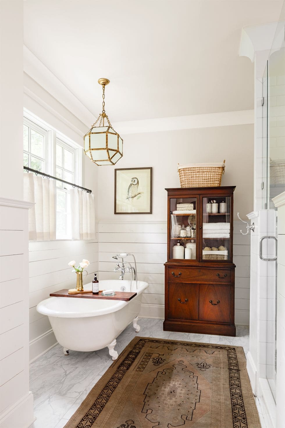 marble floors, antique wood cabinet, and clawfoot tub