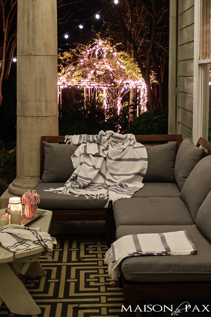 ikea couch with throw blankets, hot chocolate, and white christmas lights
