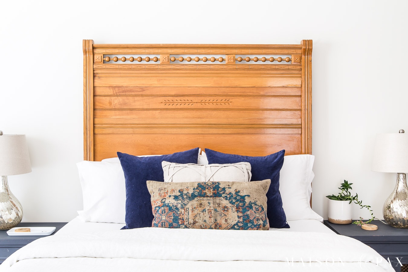 american antique wood headboard with crisp white linen bedding and velvet pillows | Maison de Pax