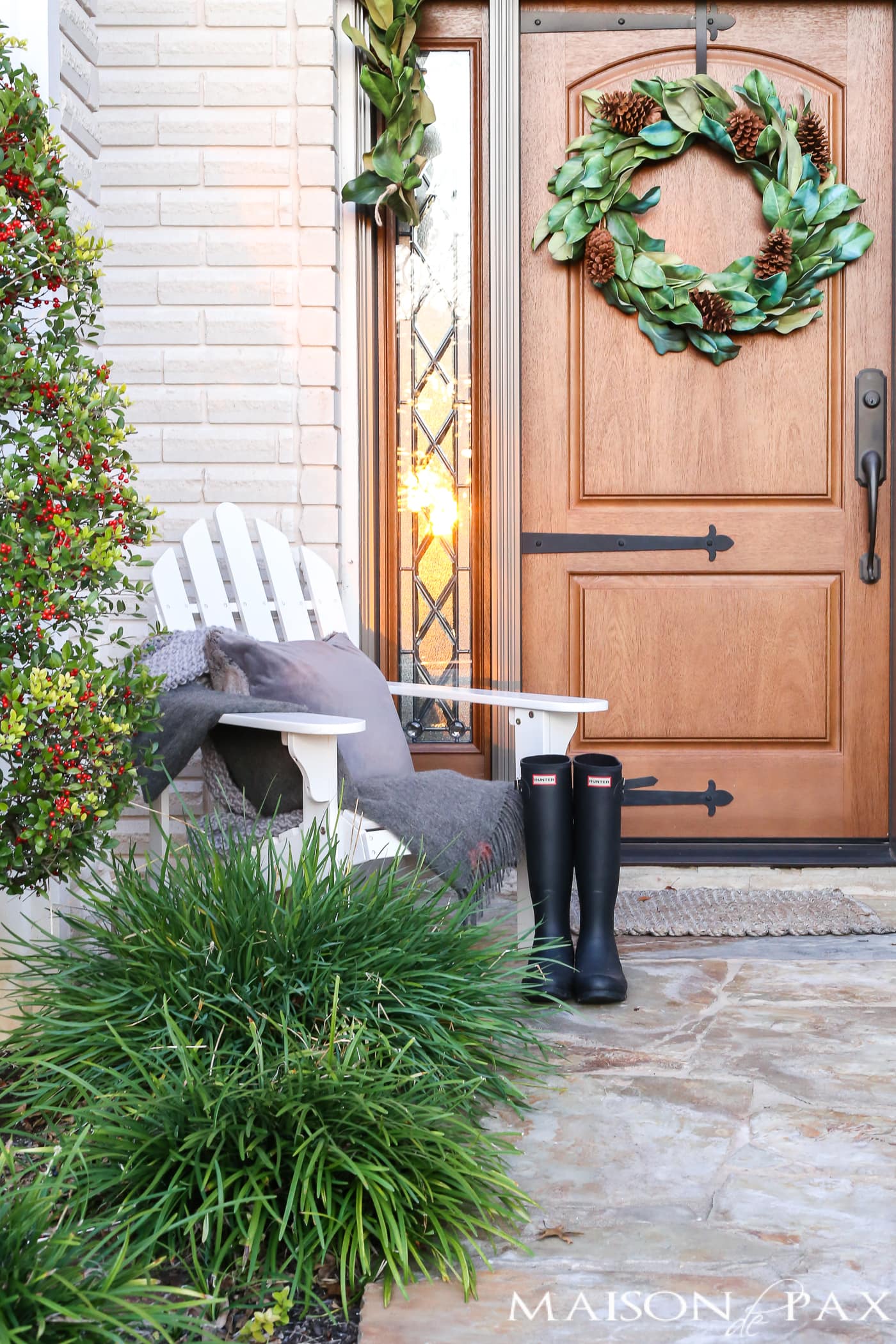 adirondack chair, gray throw, velvet pillow, and hunter boots make a cozy scene for a winter porch #winterporch
