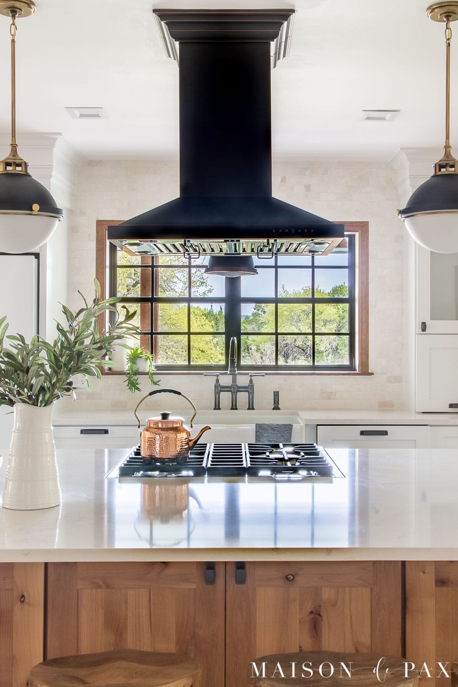 white counters and black range hood with white marble backsplash | Maison de Pax