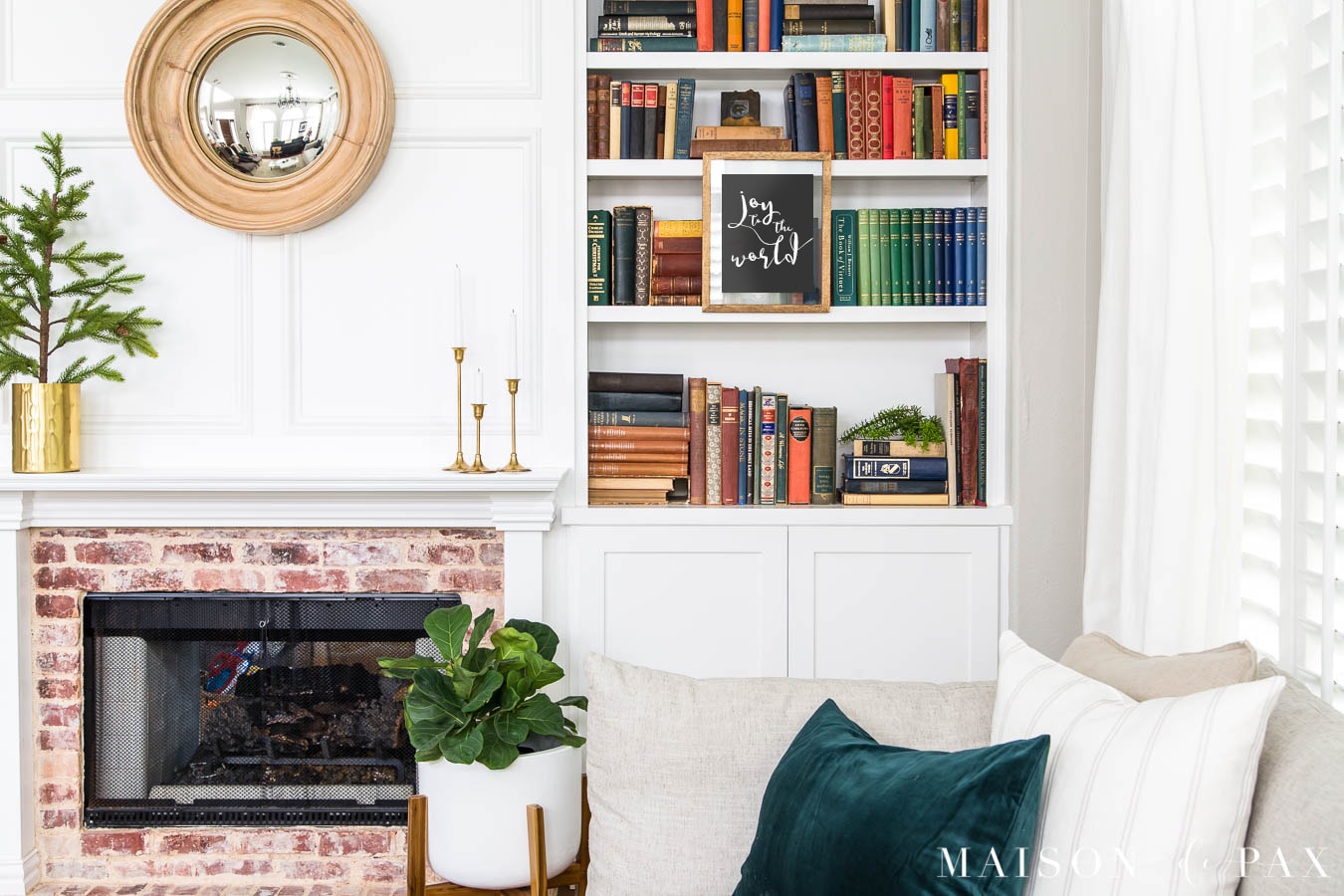 wall art hanging from bookcase beside fireplace | Maison de Pax