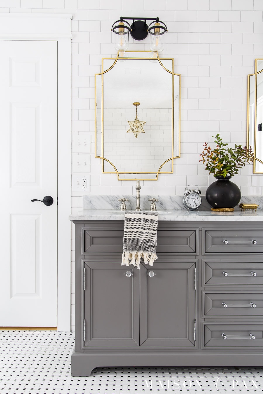 gray master bathroom vanity with gold mirrors and black and gold lights