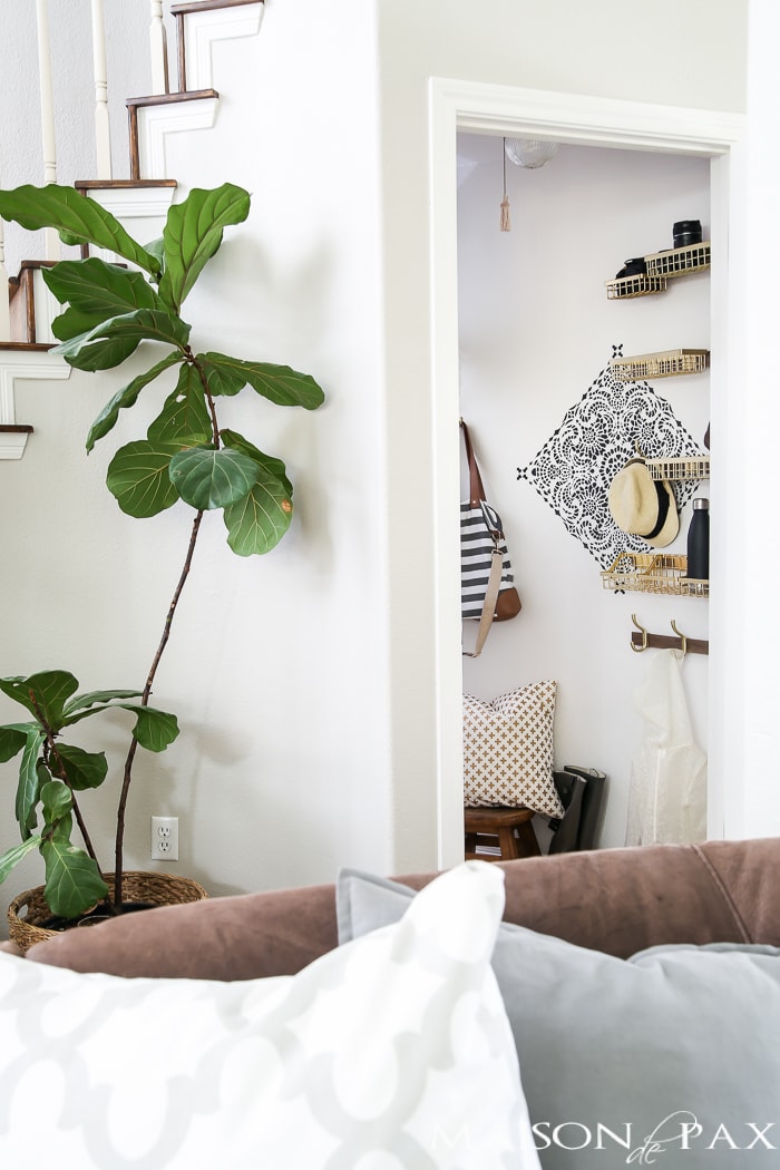 How to turn closet into mudroom: What an adorable space! Baskets and hooks turn a closet under the stairs into a functional mudroom space for a family.