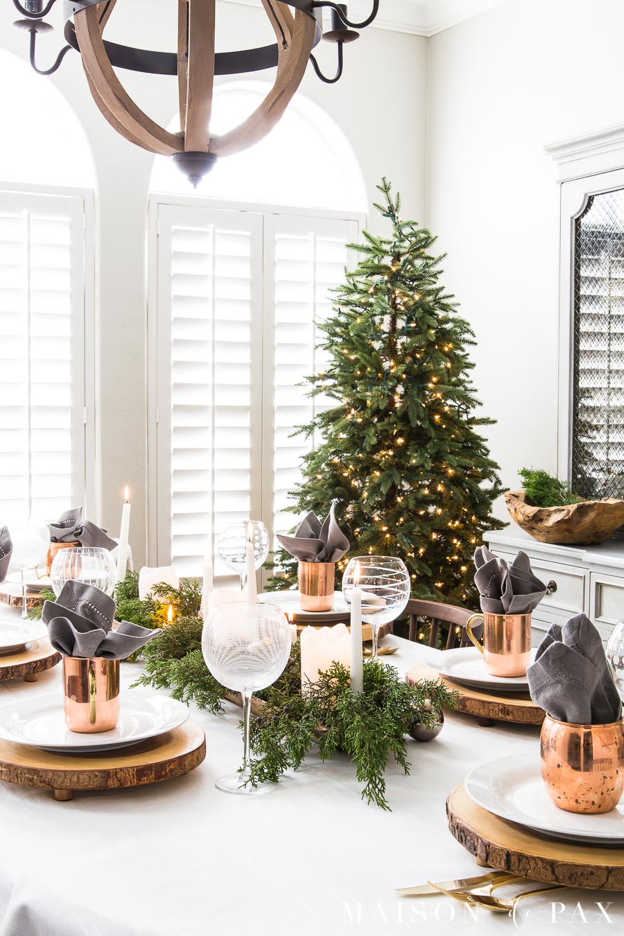 elegant green and copper holiday dining table with a simple green tree in the background