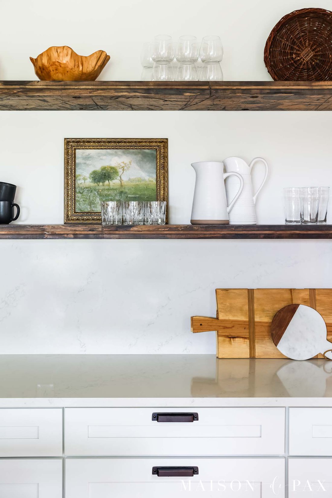 vintage art on floating shelves in kitchen with quartz countertop backsplash
