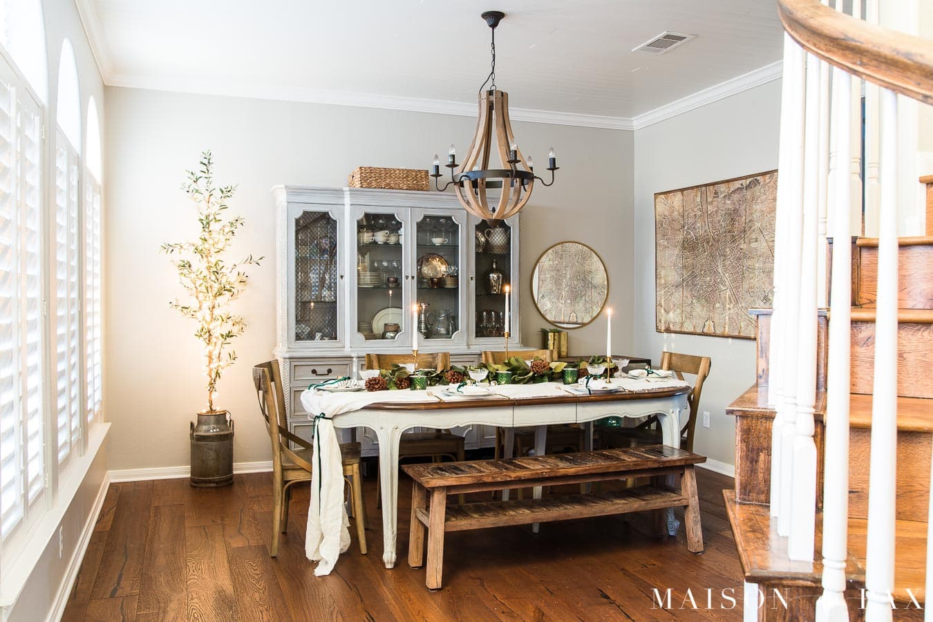 olive tree with Christmas lights beside dining table with holiday decorations | Maison de Pax