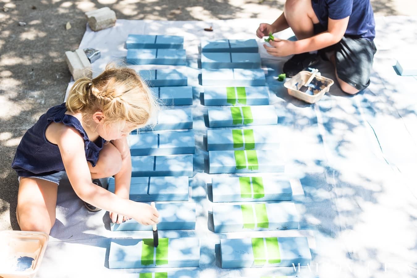 Kids building and painting giant dominoes with their parents | Maison de Pax