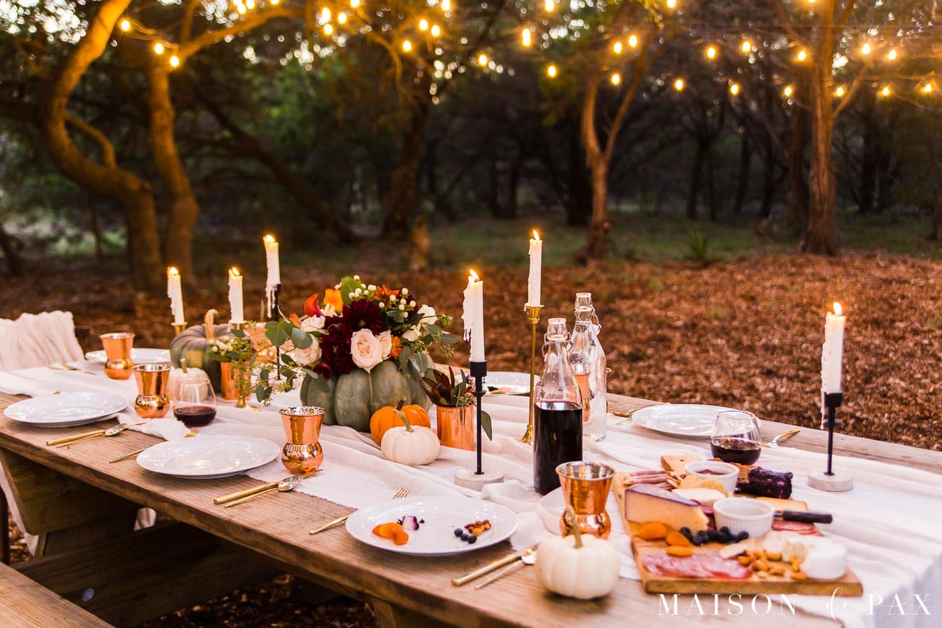 string lights over Thanksgiving table with pumpkins and candles | Maison de Pax
