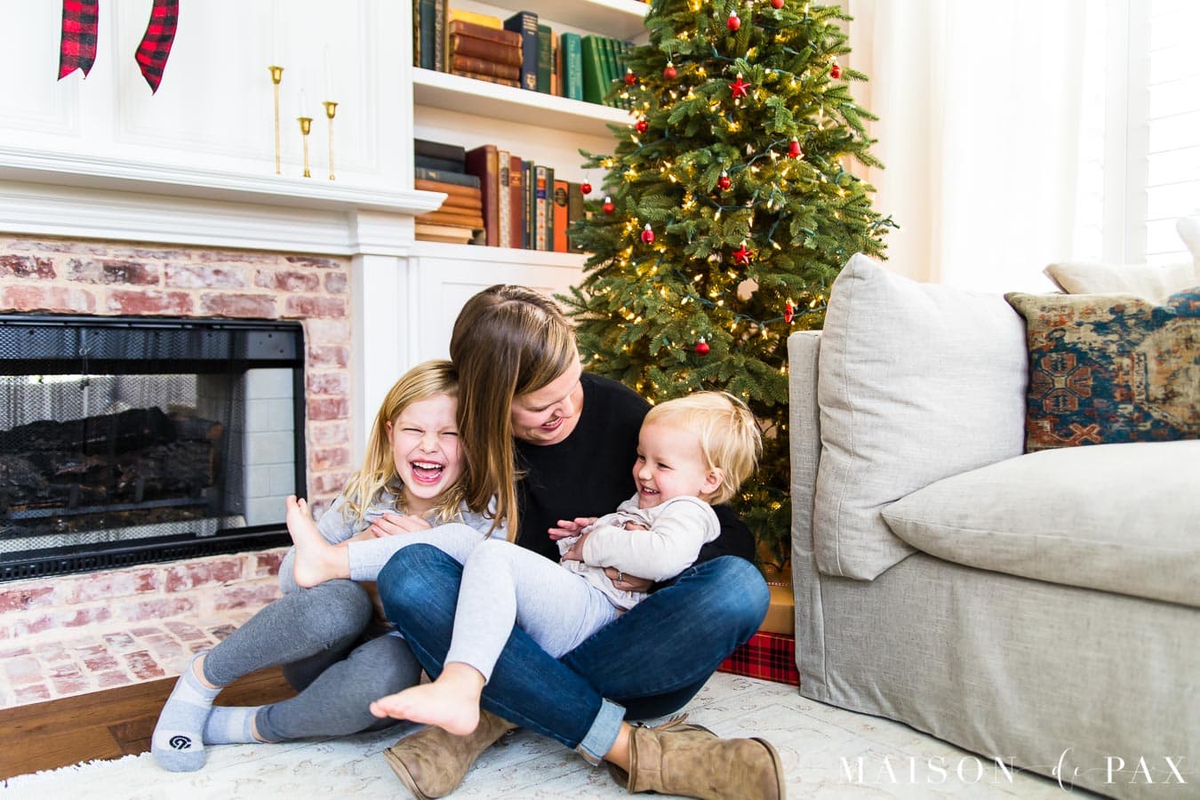 mother and daughters laughing in front of Christmas tree | Maison de Pax