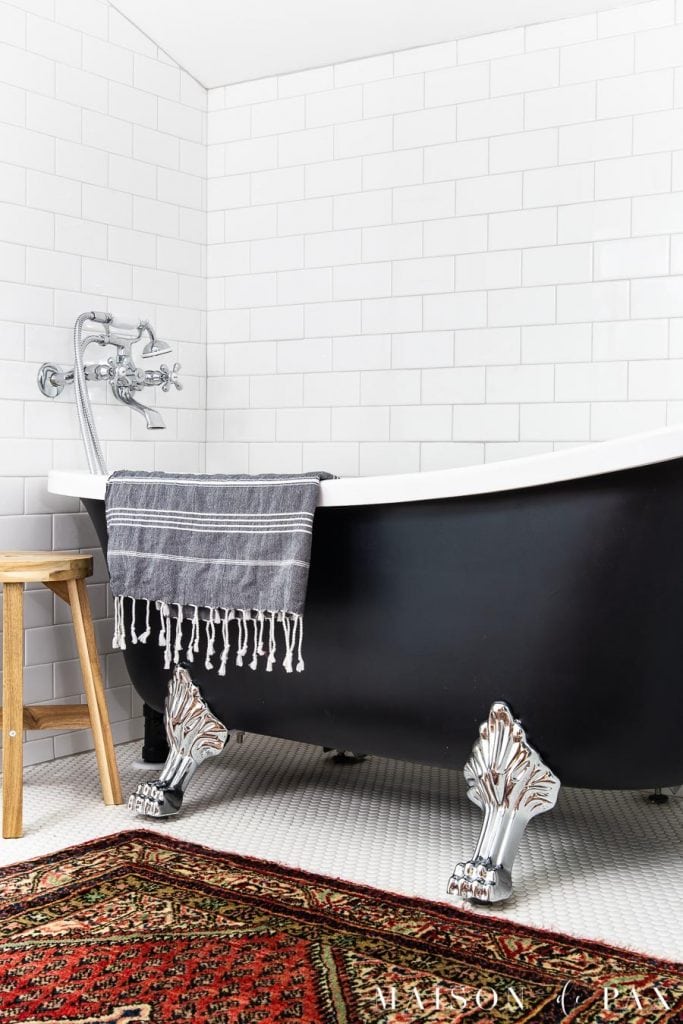 black clawfoot tub with chrome feet in white tile bathroom | Maison de Pax