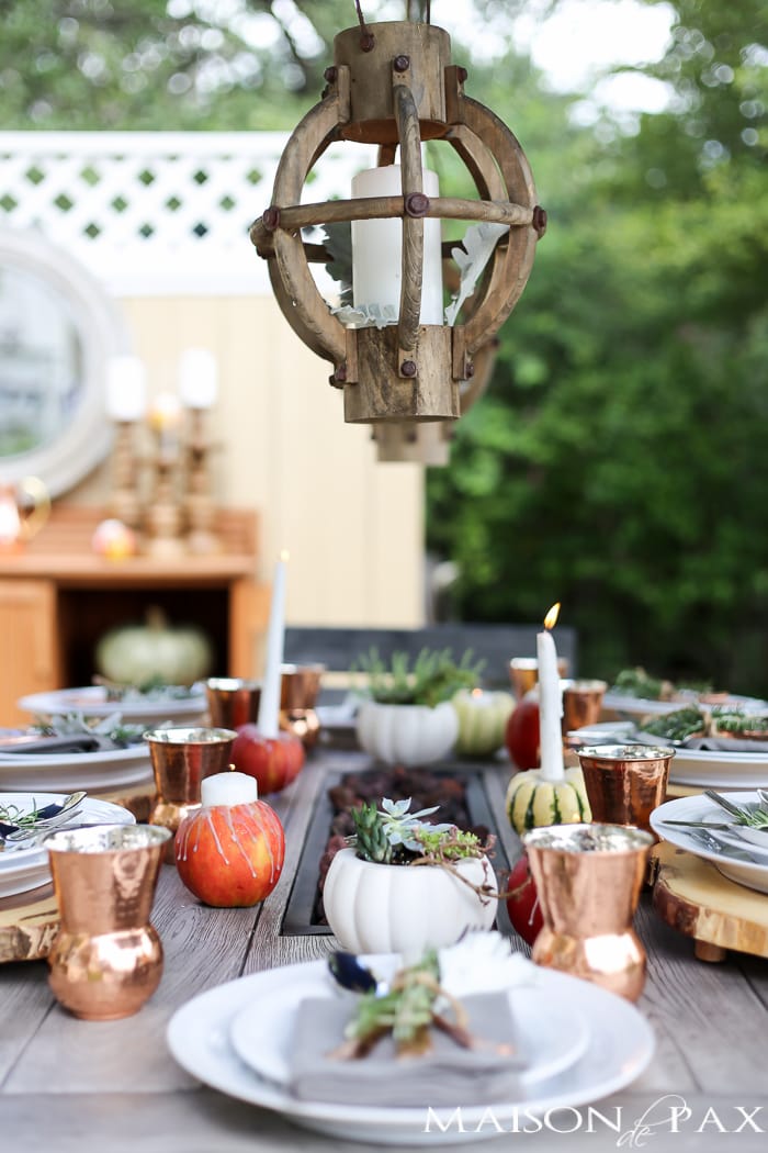 outdoor fall tablescape: lanterns, string lights, apple candles, and other cozy outdoor fall decorating ideas!
