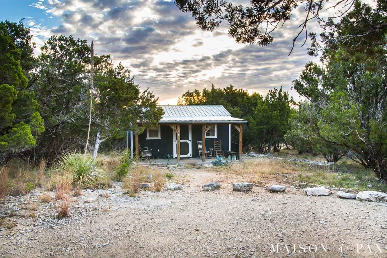 tiny black and white house in the country with a gorgeous sunrise overhead