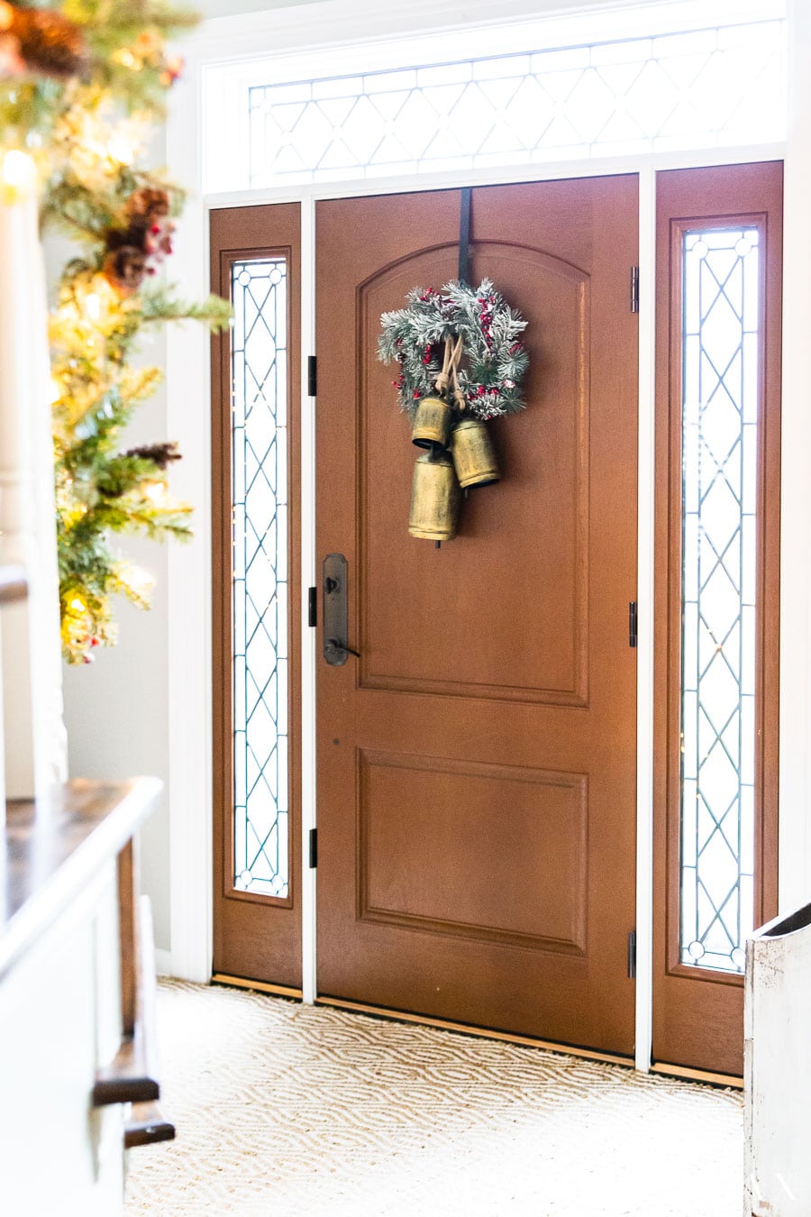 frosted wreath and gold bells on front door | Maison de Pax