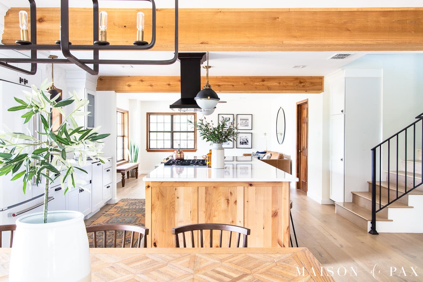 olive tree in crock on wood dining table near big kitchen island | Maison de Pax