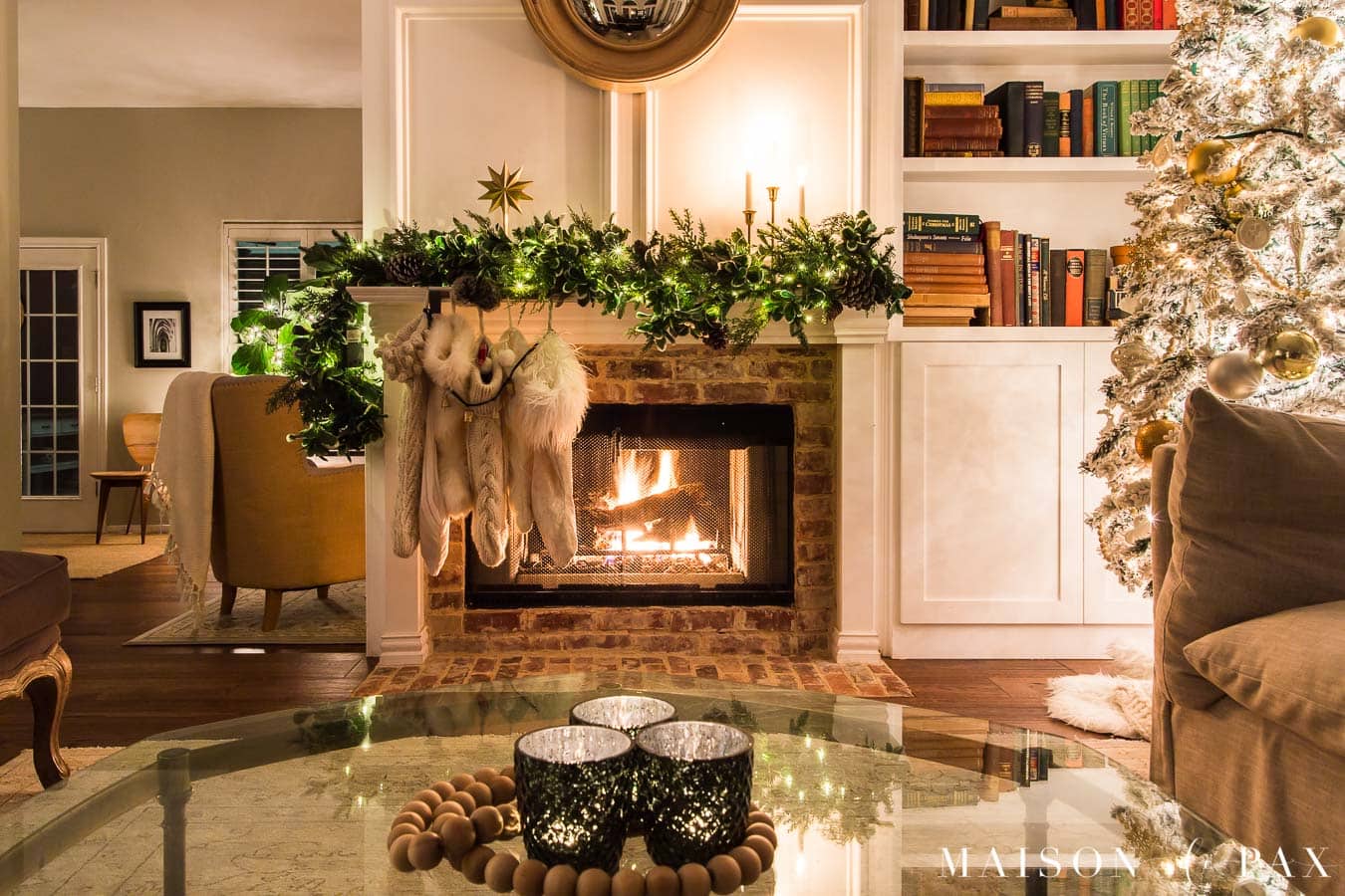 candles on the coffee table and a fire in the fireplace by the Christmas tree | Maison de Pax