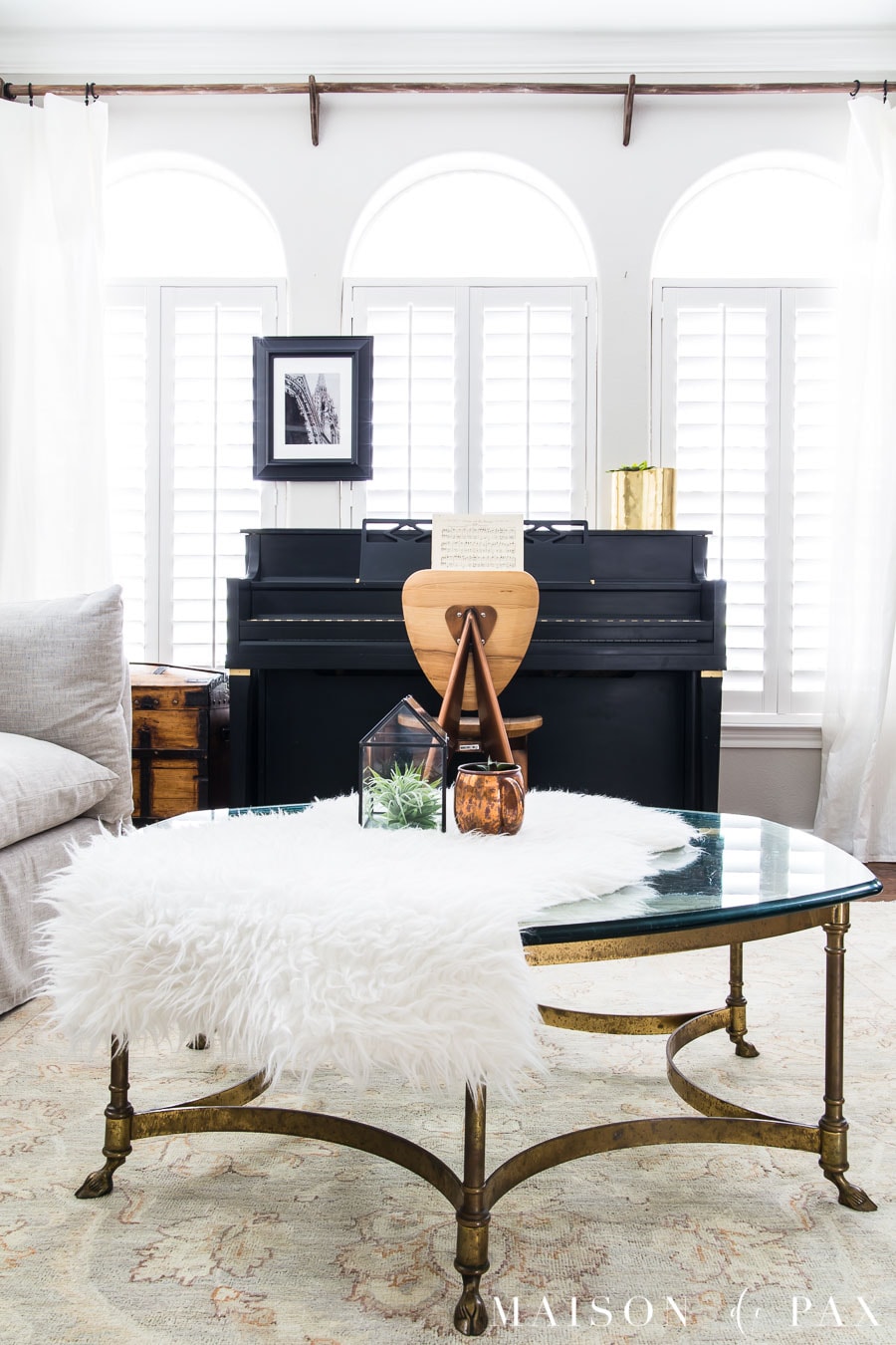 black piano, brass coffee table, faux sheepskin throw | Maison de Pax