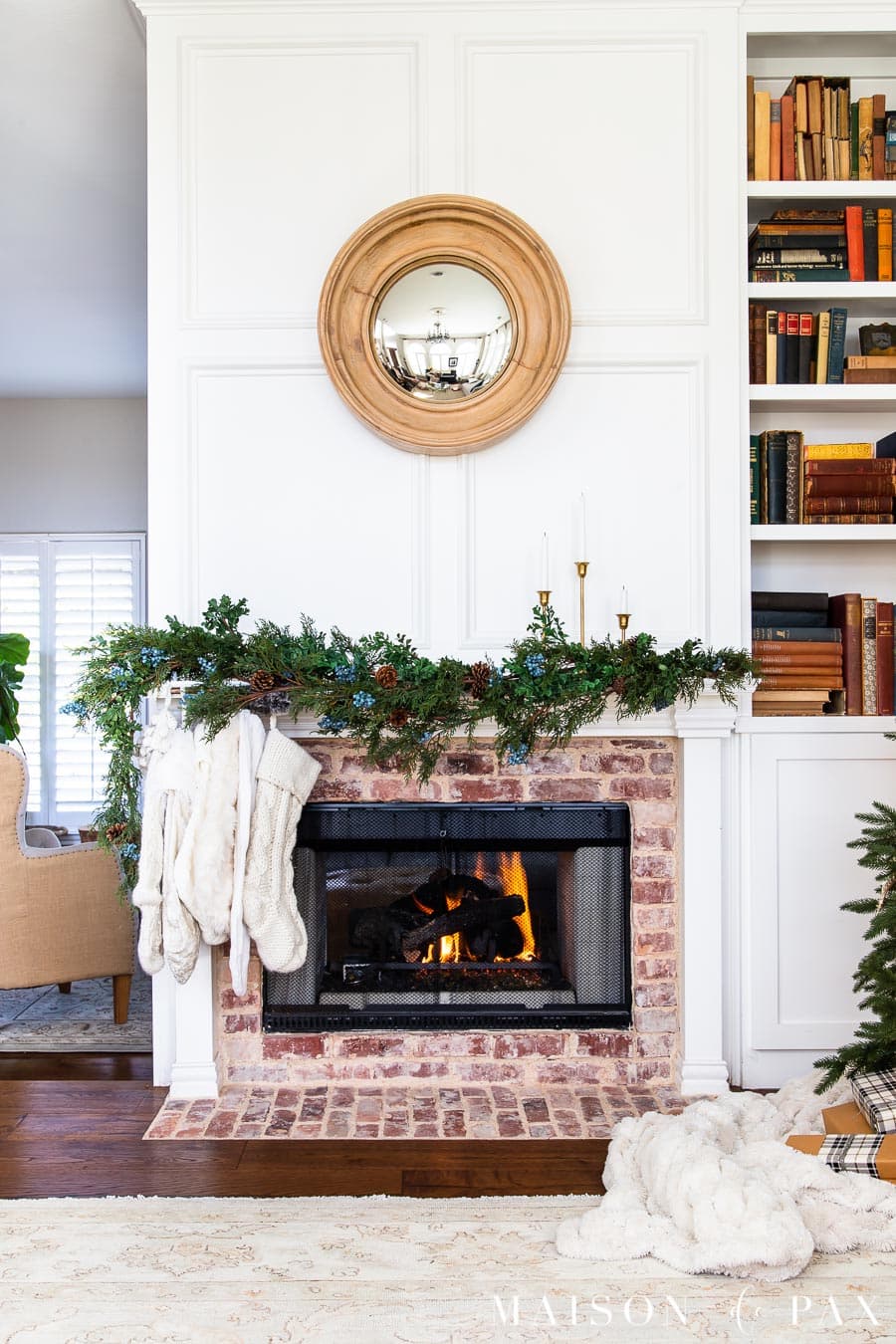 asymmetrical holiday mantel with greenery and knit stockings
